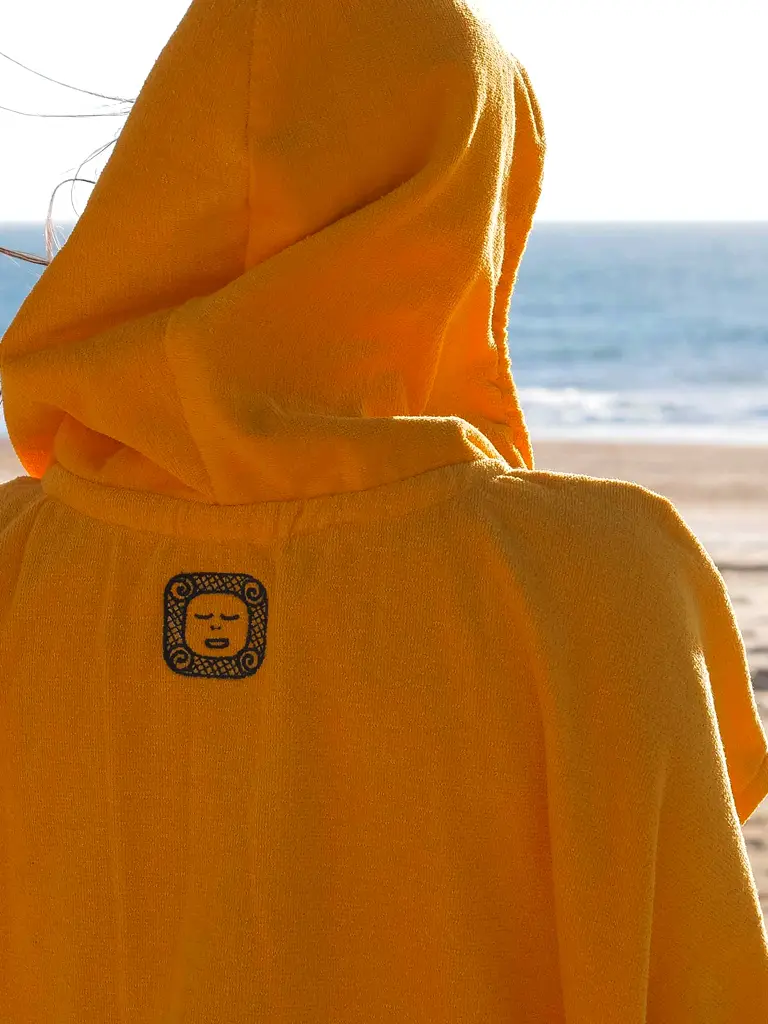 Femeie care poarta haine plaja, un poncho plaja dama culoare galben